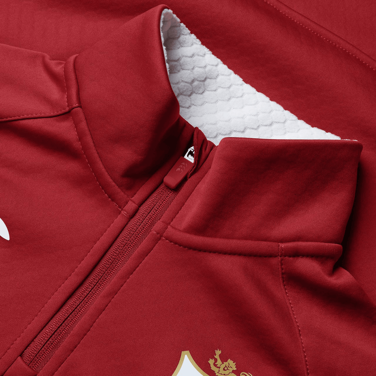 Close-up of the Women's British & Irish Lions 2025 1/4 Zip Fleece by Canterbury, showcasing a red exterior with a white textured inner lining, an embroidered golden logo, and a tailored women's fit inspired by the spirit of the British & Irish Lions.