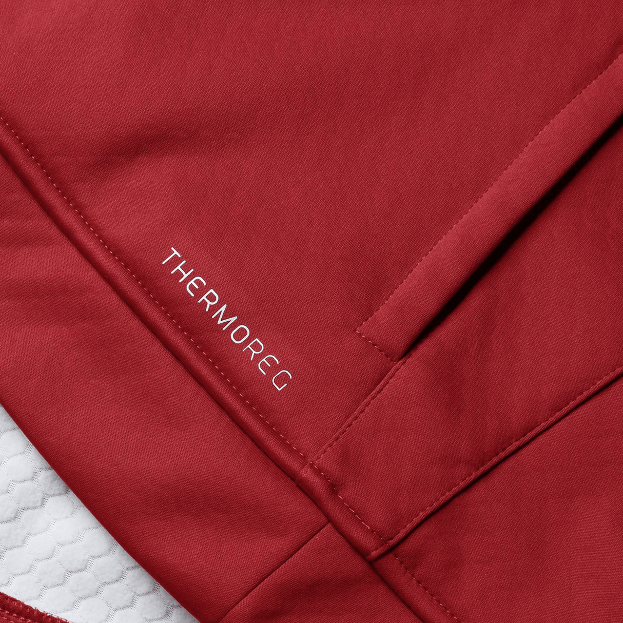 Close-up of the British & Irish Lions 2025 Women's 1/4 Zip Fleece by Canterbury in red, featuring "THERMOREG" written near a seam and a zippered pocket. The detailed fabric texture ensures warmth and style, reminiscent of the gear worn by the British & Irish Lions.