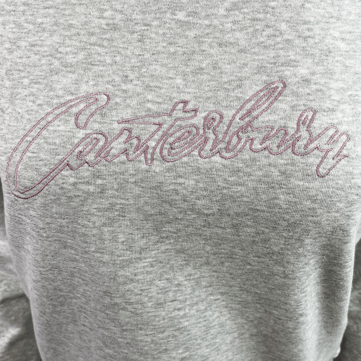The Women's Canterbury Scene Set Crew Sweatshirt features "Canterbury" stitched in pink cursive on the front. This gray sweatshirt combines comfort and style with its relaxed fit, rib knit cuffs, and hem.