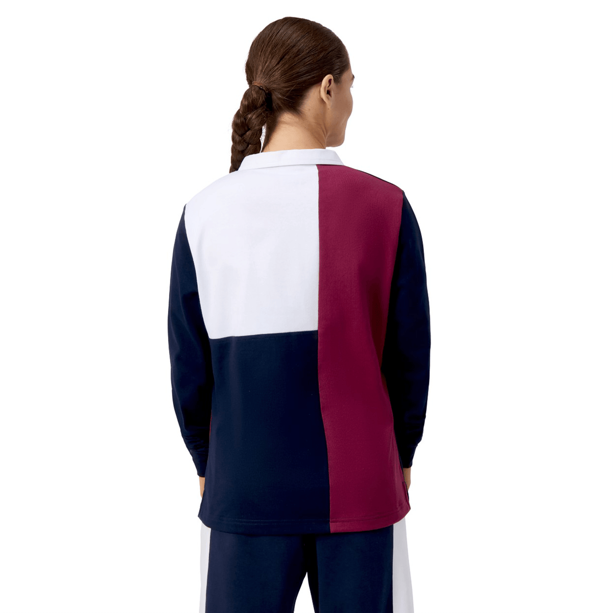A person with a braid stands facing away, wearing the Women's Canterbury Harlequin Weber Long Sleeve Rugby Jersey in white, burgundy, and navy.