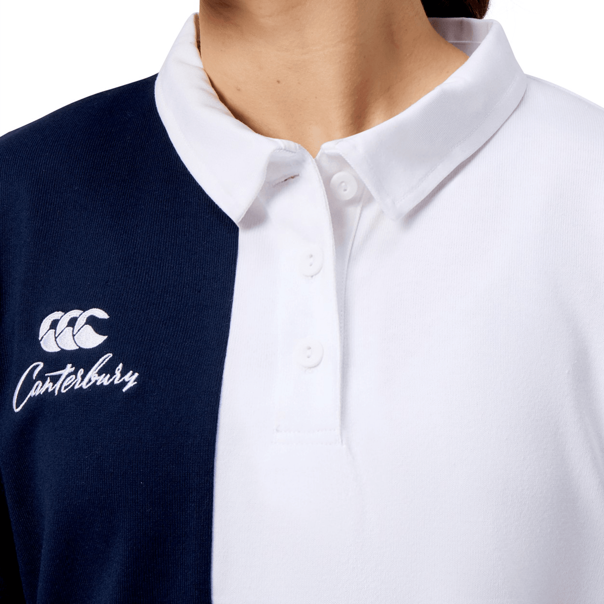 A person wears the Women's Canterbury Harlequin Weber Long Sleeve Rugby Jersey, featuring a white and navy harlequin design with the iconic Canterbury logo and text on the left.