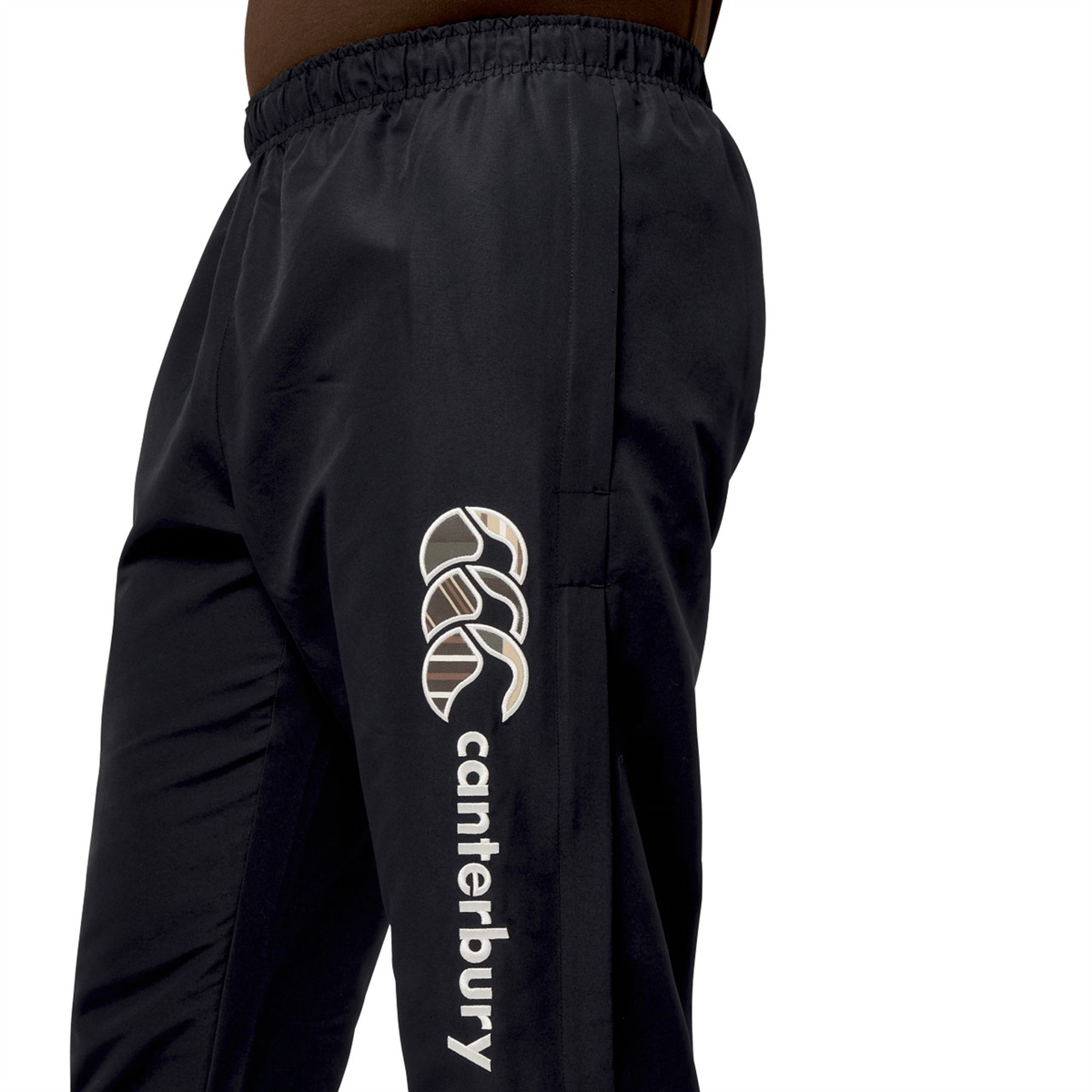 Close-up of Canterbury black Uglies Cuffed Stadium Pant showcasing a logo on the side and an elastic waistband, embodying iconic rugby style.