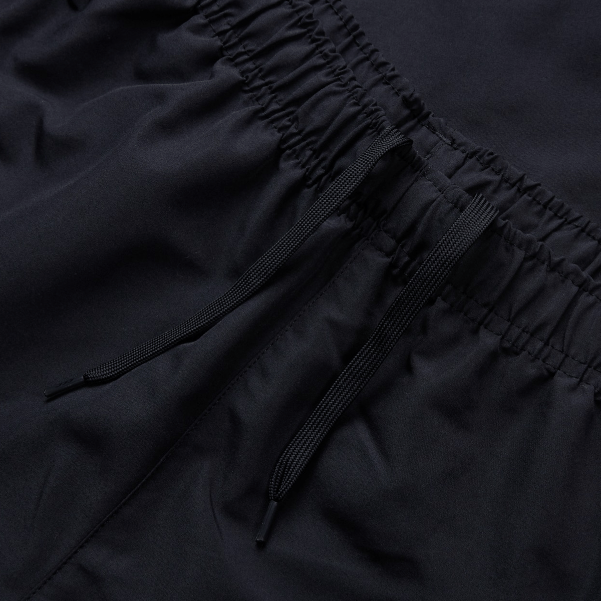 Close-up of Canterbury Uglies Cuffed Stadium Pant. With an elastic waistband, tied strings rest on the fabric, highlighting Rugby Style's texture and stitching details.