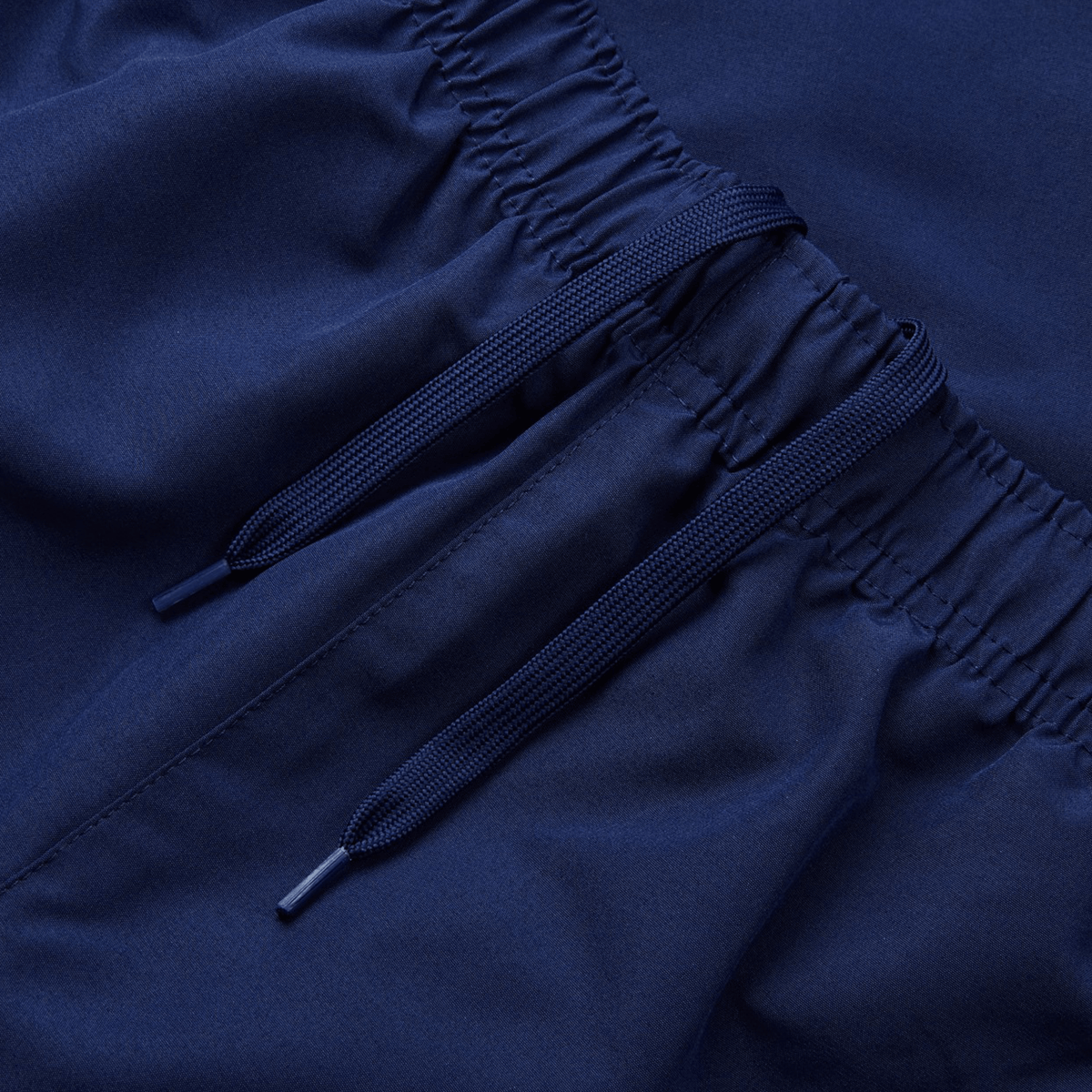 Close-up of Canterbury Uglies Cuffed Stadium Pant fabric in navy, featuring dual dark blue strings with plastic tips, elastic waistband, and a touch of Rugby Style flair.