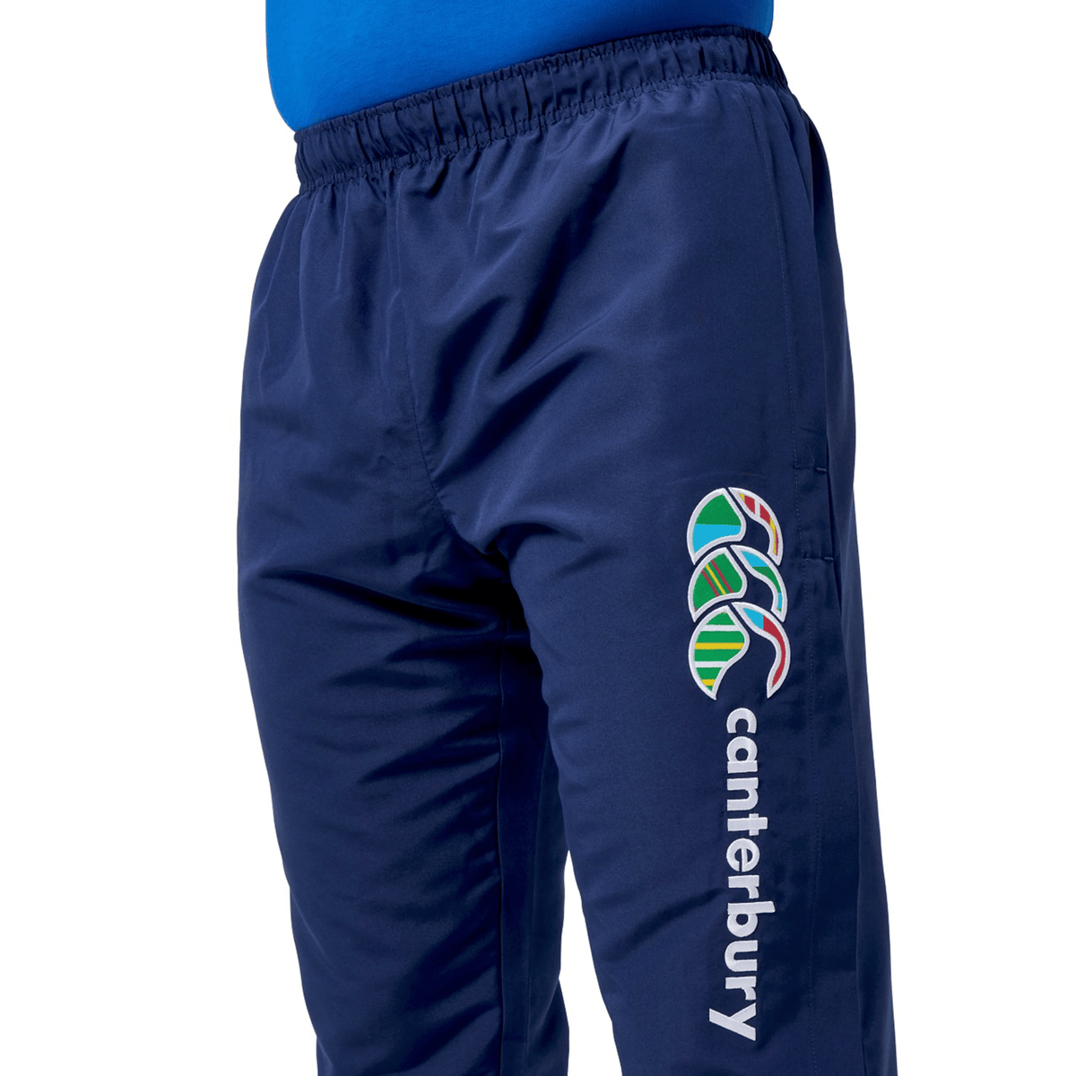 The Canterbury Uglies Cuffed Stadium Pant features a navy design with a colorful Canterbury logo and "canterbury" text on the thigh, embodying classic rugby style. Pair them with a blue shirt for the ultimate casual stadium look.
