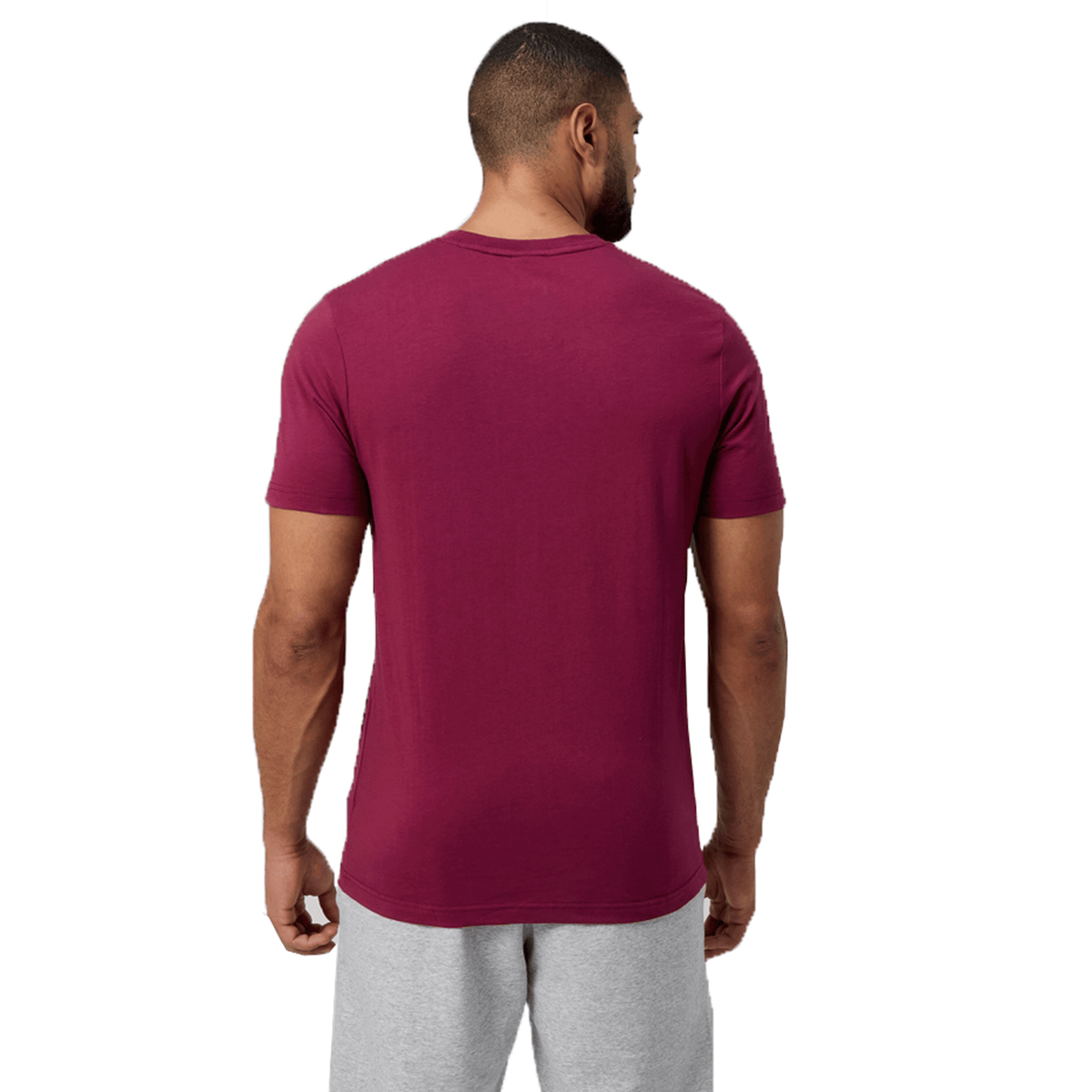 A man wearing a Canterbury Fundamental T-Shirt and gray shorts faces away, showcasing the CCC logo on his maroon outfit.