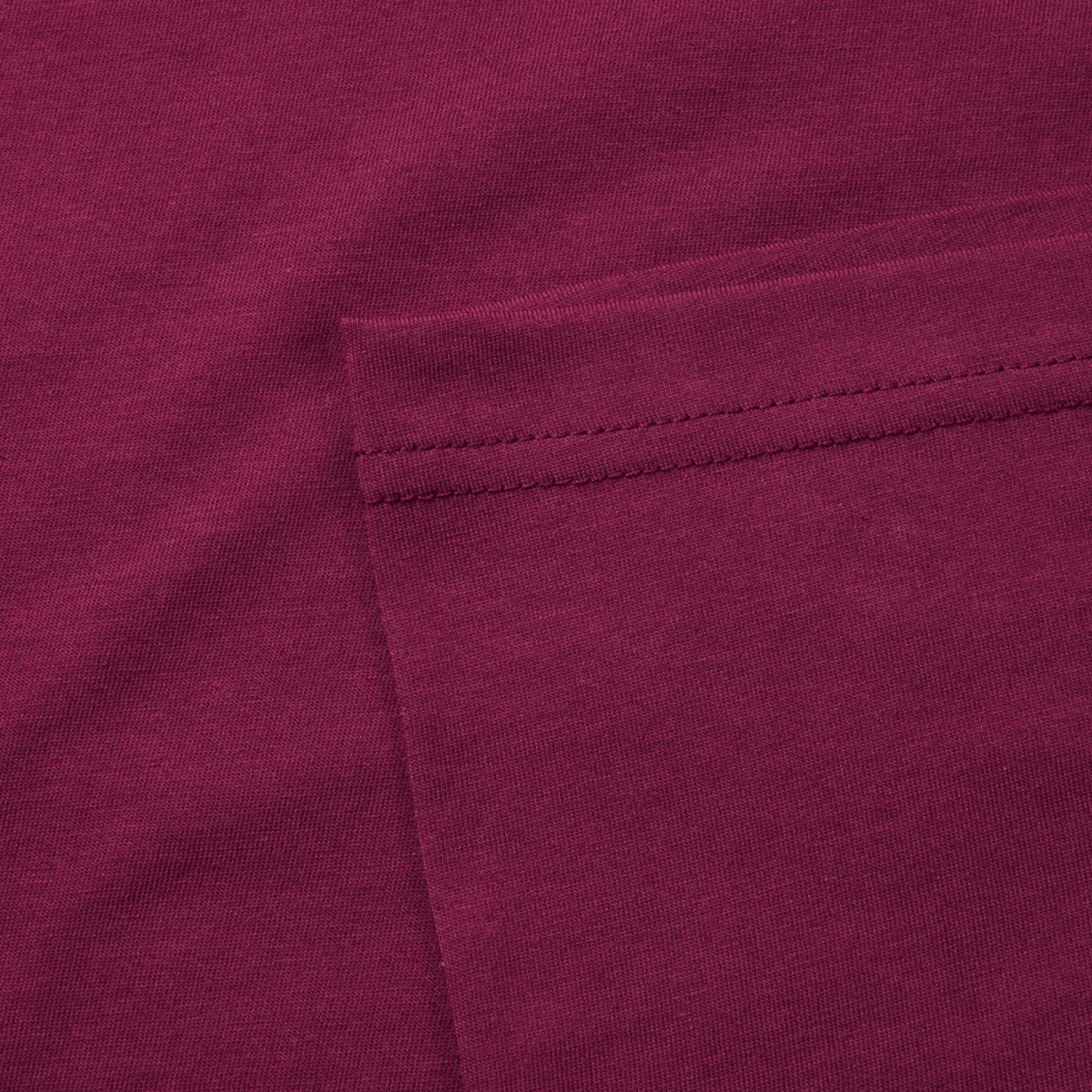 Close-up of maroon fabric with a stitched pocket and CCC logo, perfect for fans of the Canterbury Fundamental T-Shirt's classic fit.