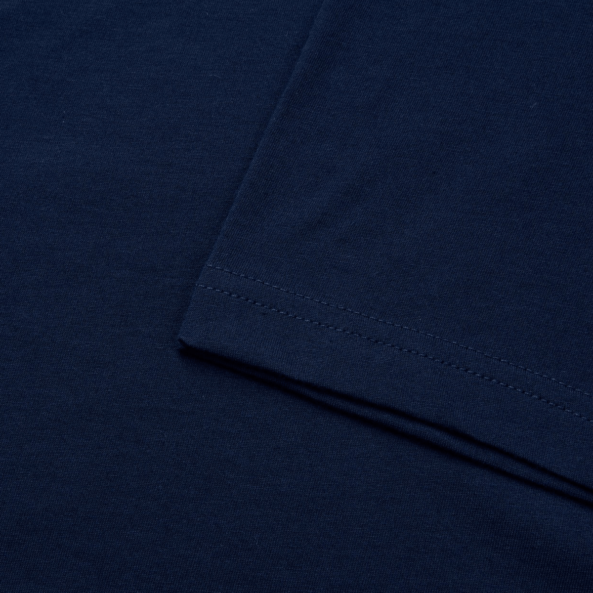 Close-up of a Canterbury Fundamental T-Shirt in navy blue, showcasing the fabric texture and sleeve seam. Its classic fit by Canterbury ensures comfort, ideal for daily use.