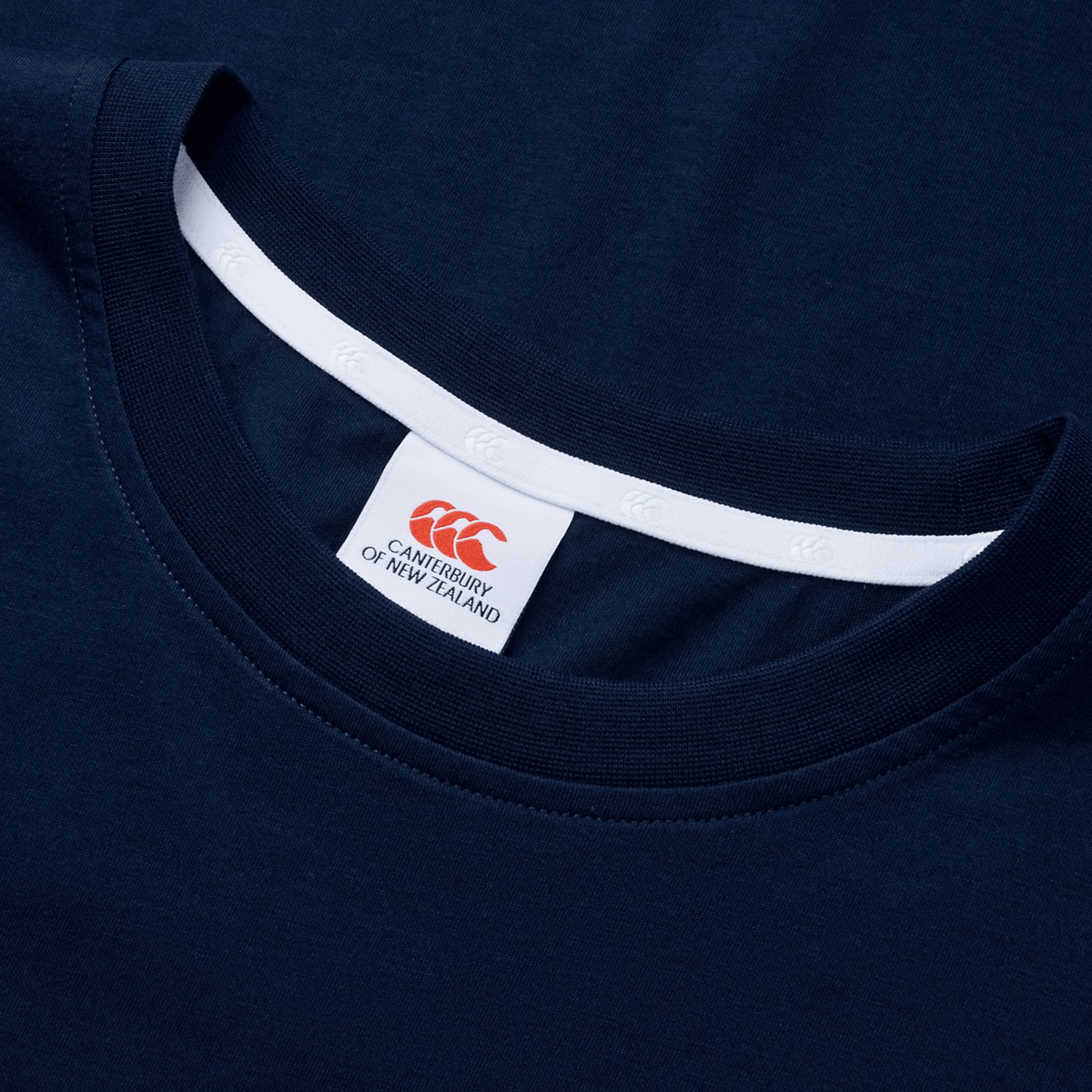 Close-up of a navy blue Canterbury T-Shirt, highlighting its classic fit. The collar and label feature "Canterbury" and the iconic CCC logo.