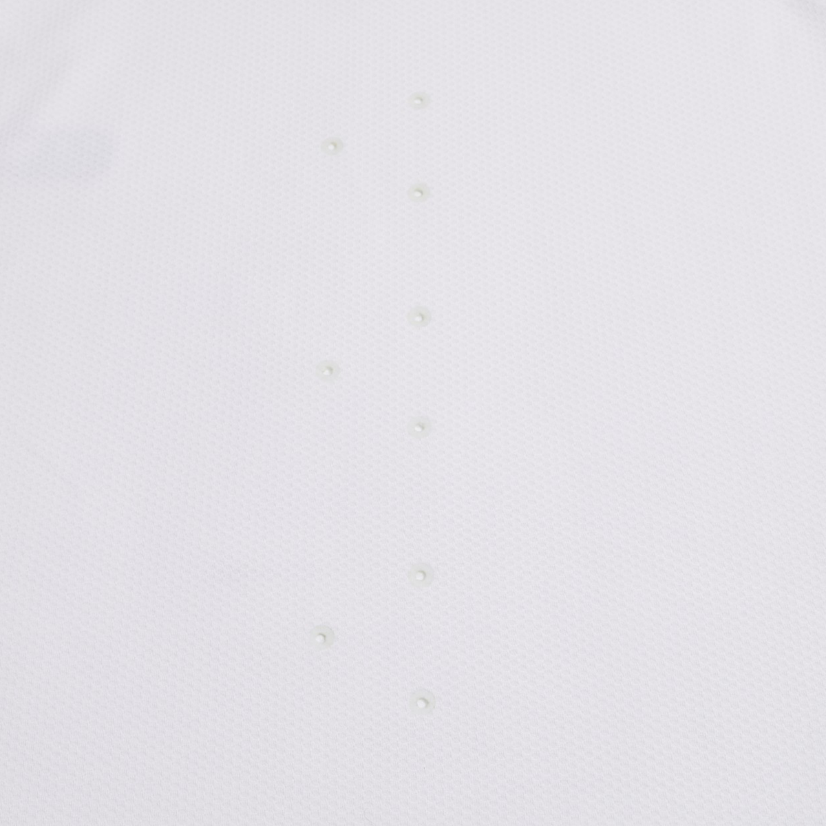 The Everest Training Tee by Canterbury features a plain white textured surface with two vertical rows of evenly spaced round bumps, inspired by the performance fit of a rugby training shirt.