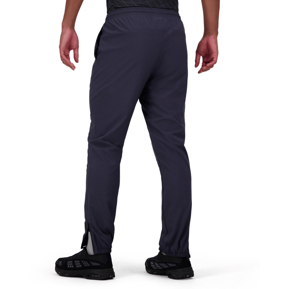 Rear view of a person in Canterbury Tempo+ Training Trackpant by Canterbury, featuring a tapered fit, paired with black sneakers.