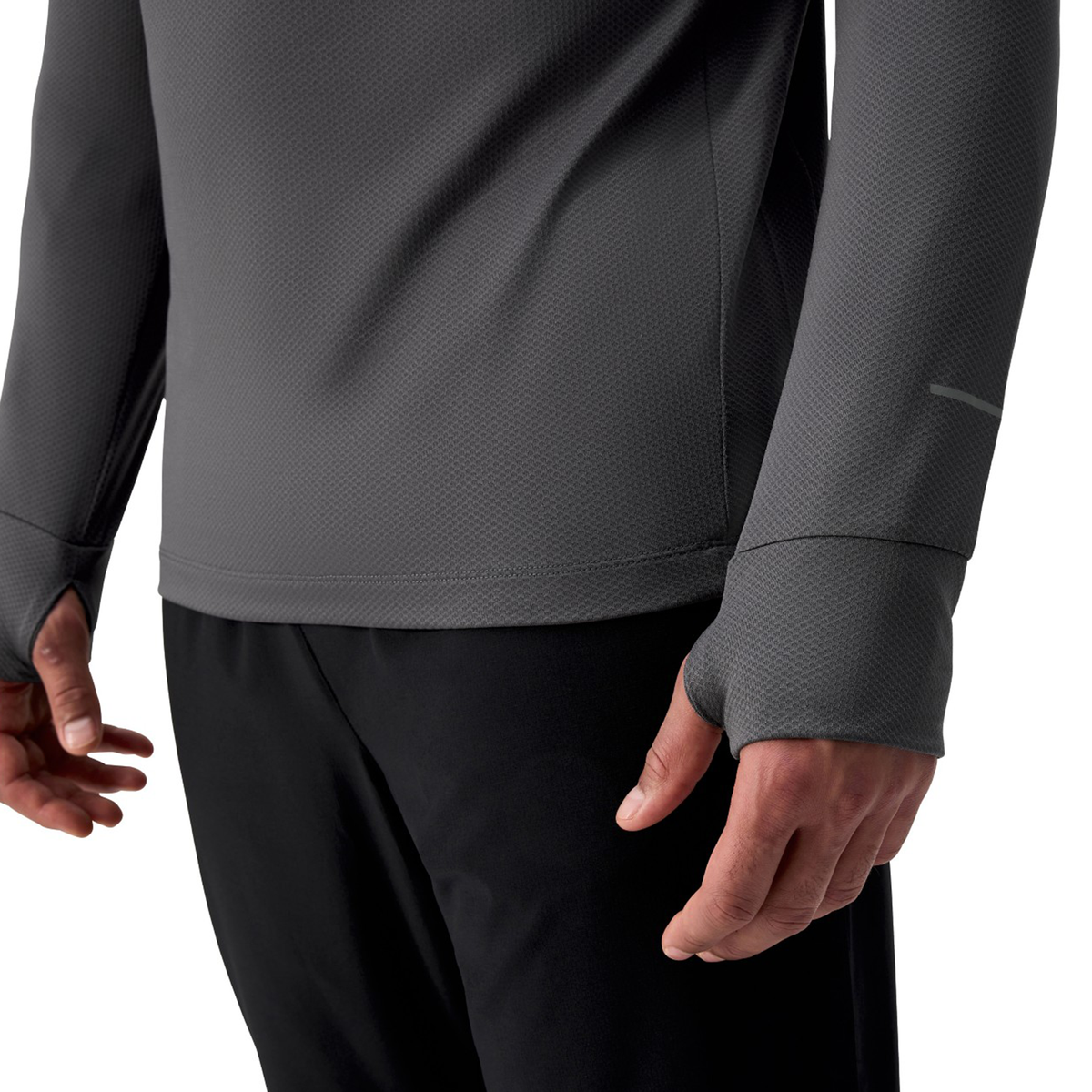 Person wearing a Canterbury Tempo+ 1/4 Zip Training Top in gray with thumb holes and black pants, torso shown.