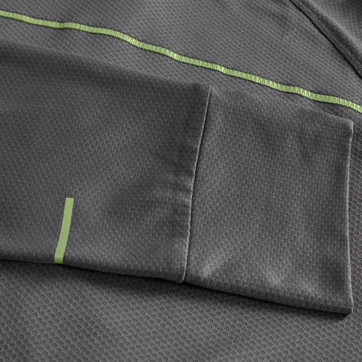 Close-up of the Canterbury Tempo+ 1/4 Zip Training Top in gray, showcasing a textured fabric, pocket detail, and light green stripe accents.