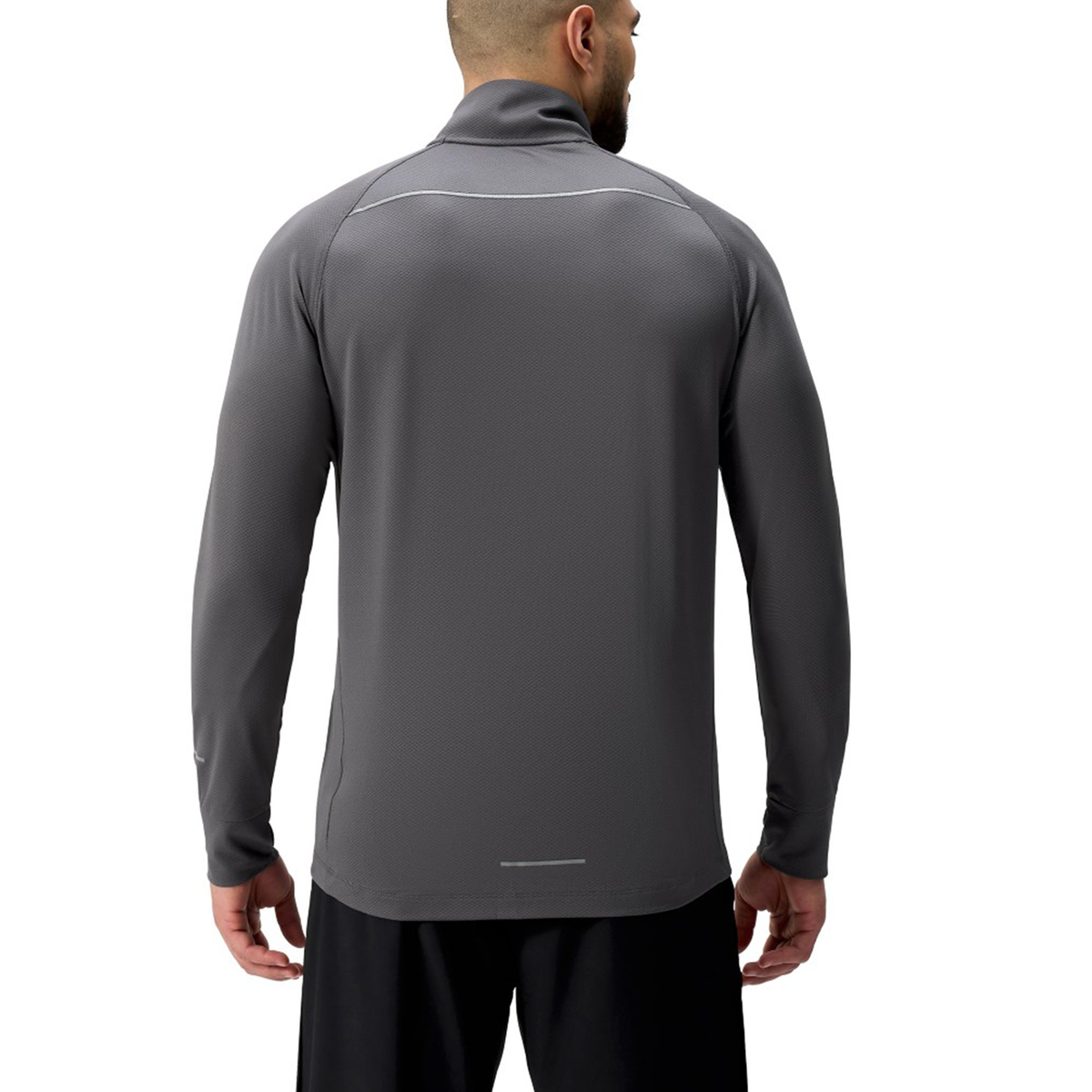 A man faces away wearing the Canterbury Tempo+ 1/4 Zip Training Top in dark gray with black shorts, set against a plain white background.