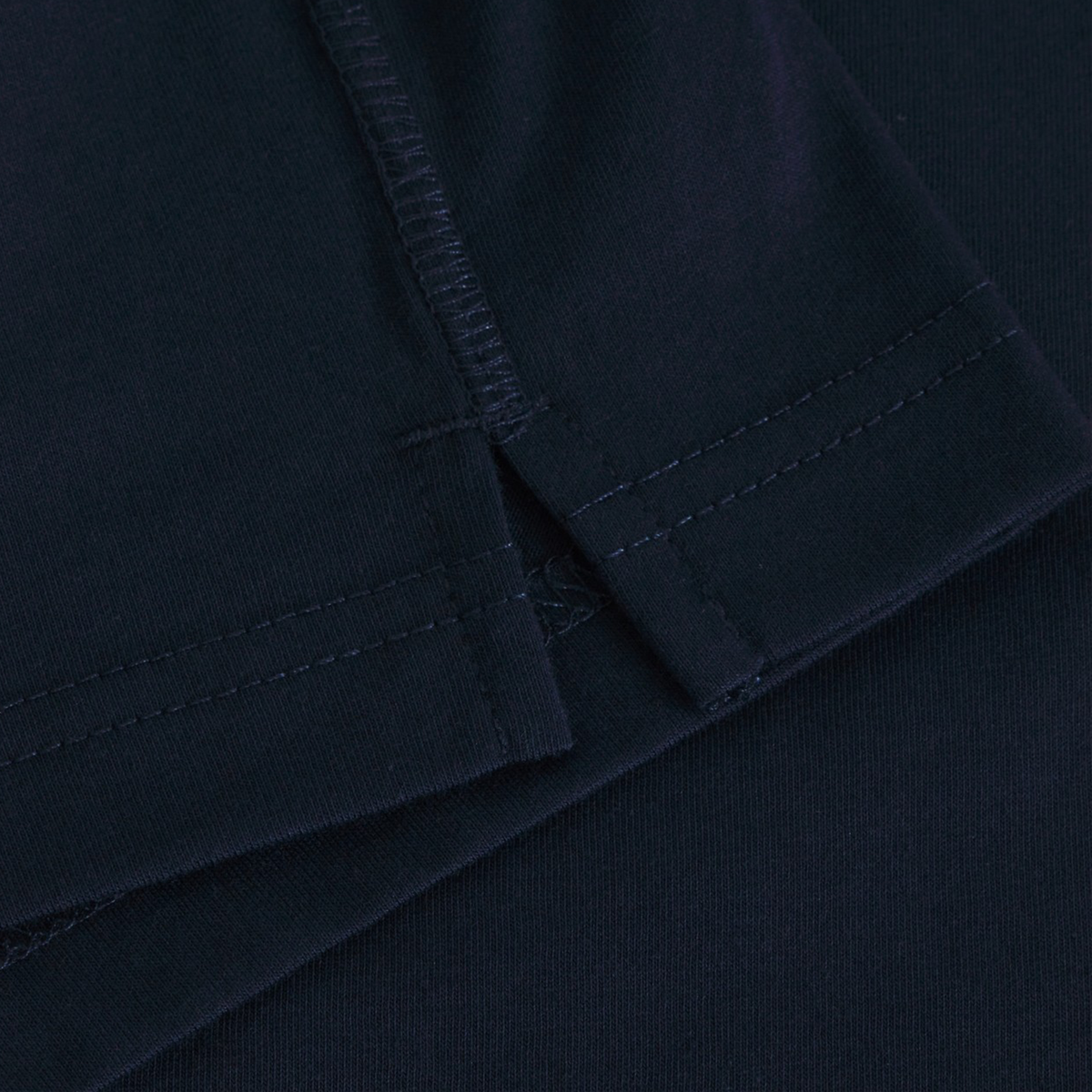 Close-up of the hem and seam of the dark navy Fundamentals CCC Logo Tank by Canterbury, highlighting stitching details and fabric texture inspired by Fundamentals.