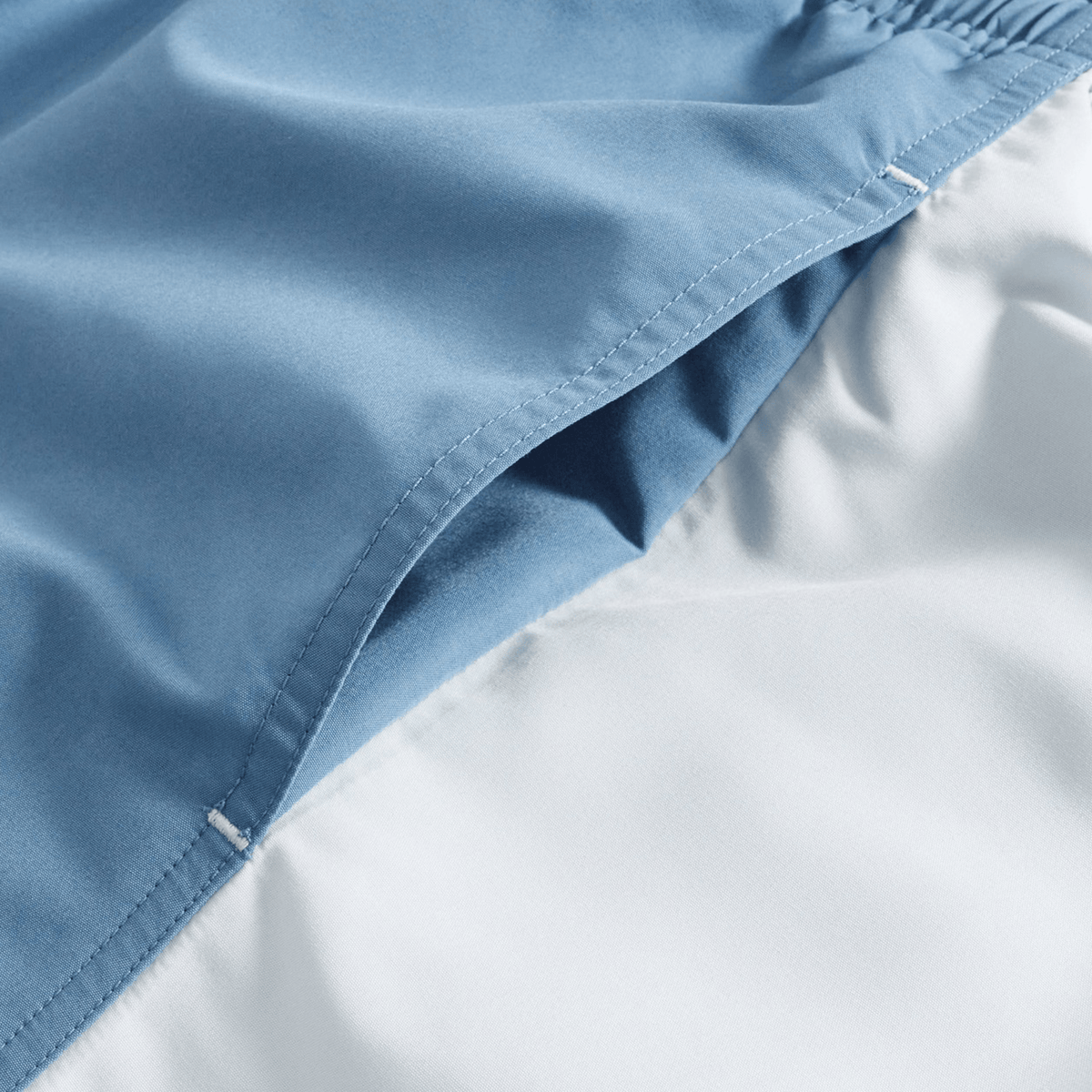 Close-up of the Canterbury Fundamental Harletic 3″ Rugby Shorts by Canterbury in light blue, featuring a visible seam, pocket detail, and a 3-inch inseam, displayed on a white background.