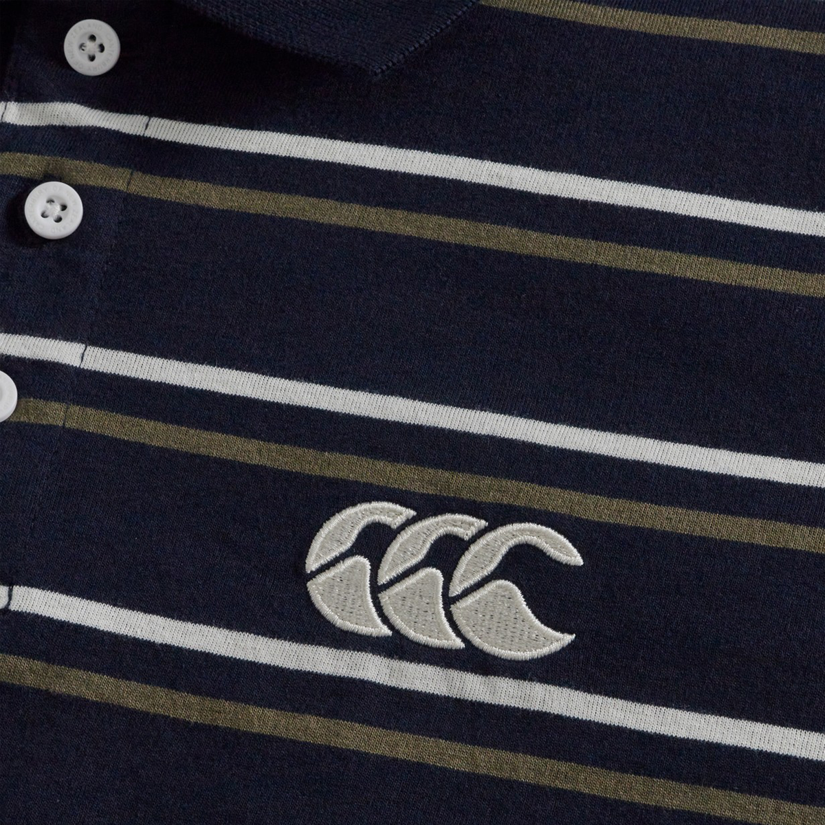 Close-up of the Fundamental Yarn Dye Stripe Polo by Canterbury in navy, with white buttons, horizontal white and olive stripes, and a white embroidered Canterbury logo.
