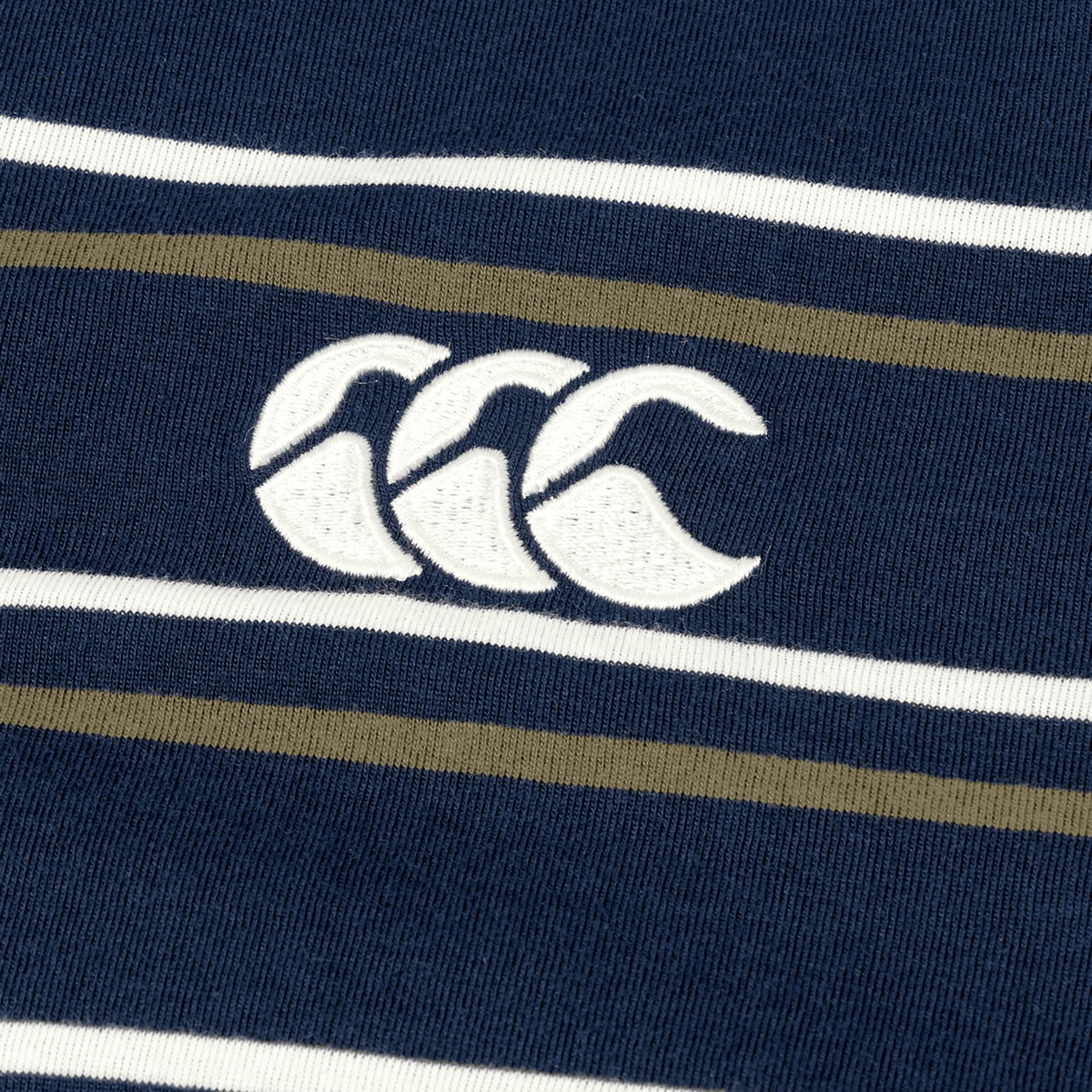 Here’s a revised version using your product data: Close-up of the Canterbury Yarn Dye Stripe Polo in navy blue, highlighted by white and olive stripes and the iconic embroidered white Canterbury rugby logo. This polo exemplifies classic Canterbury craftsmanship, making it a standout addition to any rugby enthusiast's wardrobe.