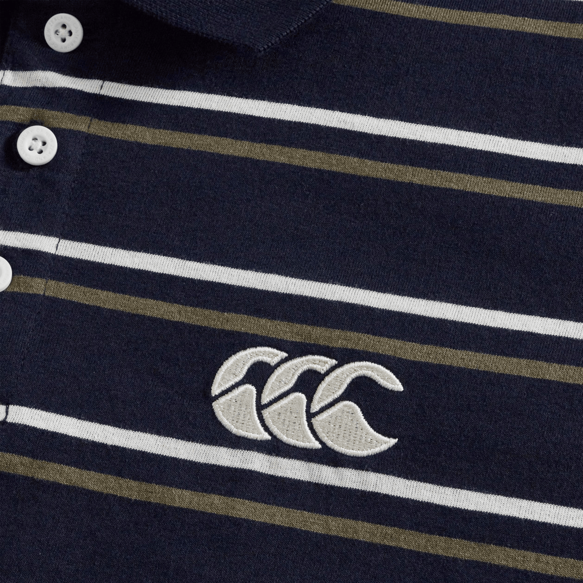Close-up of the Canterbury Yarn Dye Stripe Polo by Canterbury in navy blue, showcasing white and olive green stripes, classic white buttons, and an embroidered white logo with three overlapping shapes—a perfect choice for fans of timeless rugby polo style.