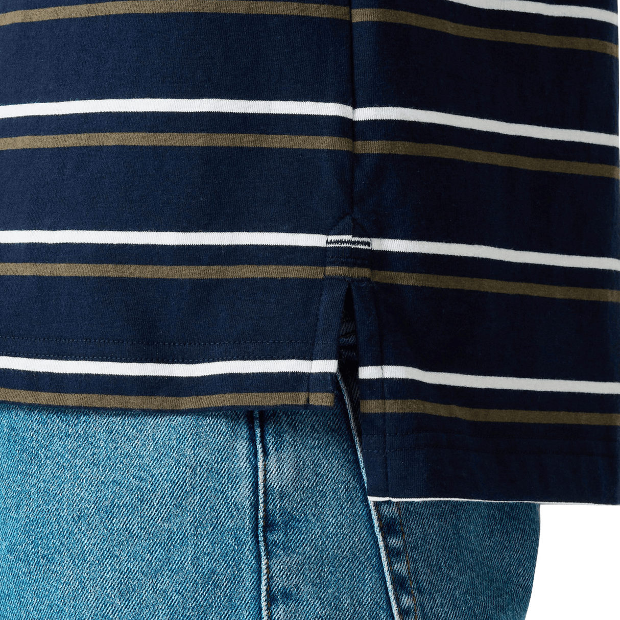 Close-up of the Canterbury Yarn Dye Stripe Polo by Canterbury, showcasing its navy blue and white stripes inspired by classic rugby designs, featuring a small side slit and styled over light blue denim jeans.