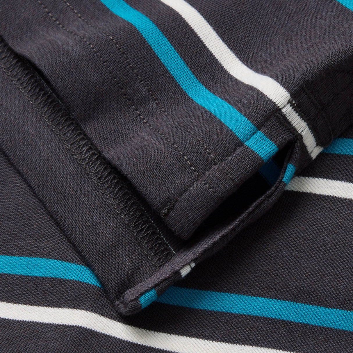 Close-up of a folded Canterbury Yarn Dye Stripe Polo by Canterbury, showcasing horizontal blue, white, and light gray yarn-dyed stripes on a dark gray background.