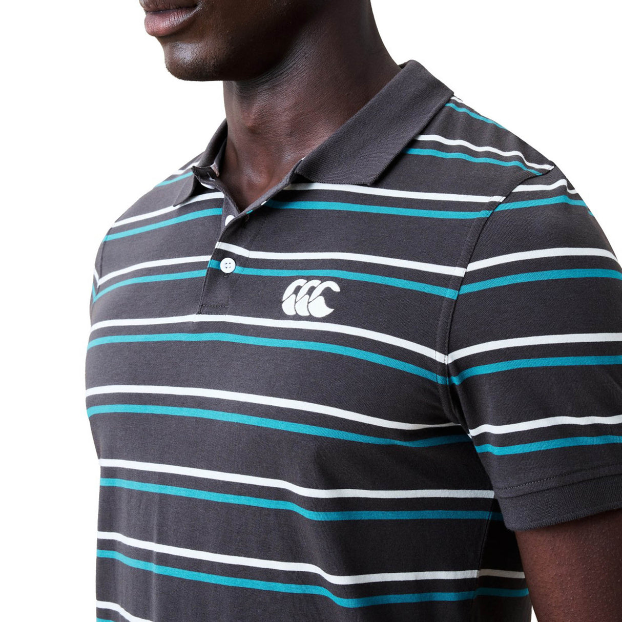 A man is shown from the shoulders down wearing the Canterbury Yarn Dye Stripe Polo by Canterbury, a dark collared shirt featuring yarn-dyed stripes and a white logo on the chest, set against a white background.