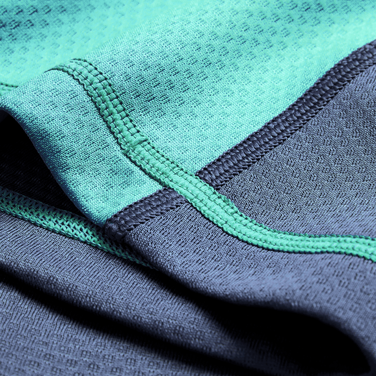 Close-up of turquoise and dark gray athletic fabric with visible stitching, from the Ireland 26/27 Summer Tour "Baltic" Training Test Jersey by Canterbury.