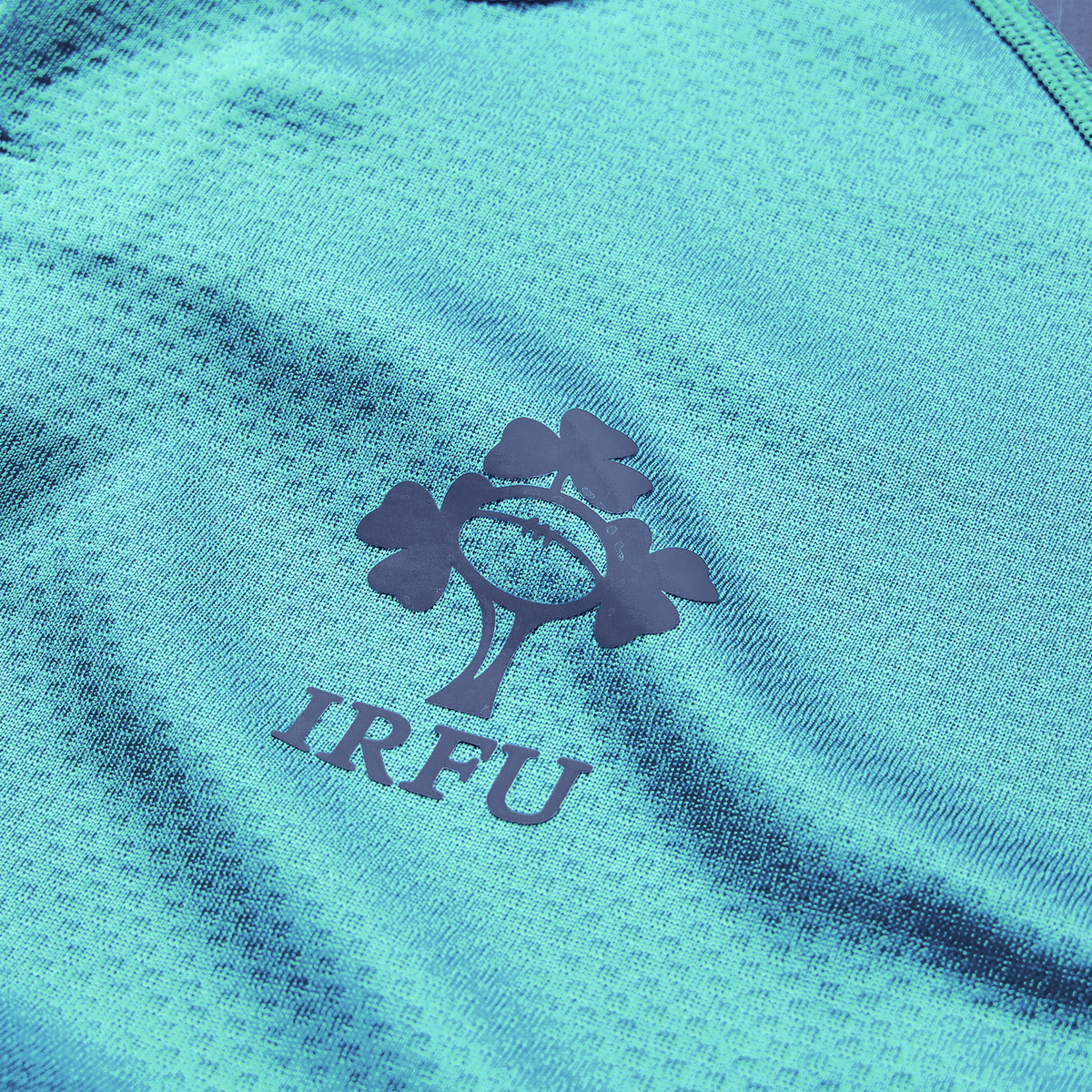 Close-up of the Ireland 26/27 Summer Tour "Baltic" Training Test Jersey by Canterbury, featuring the IRFU logo with a rugby ball and three shamrocks—ideal for showing support during the summer tour.