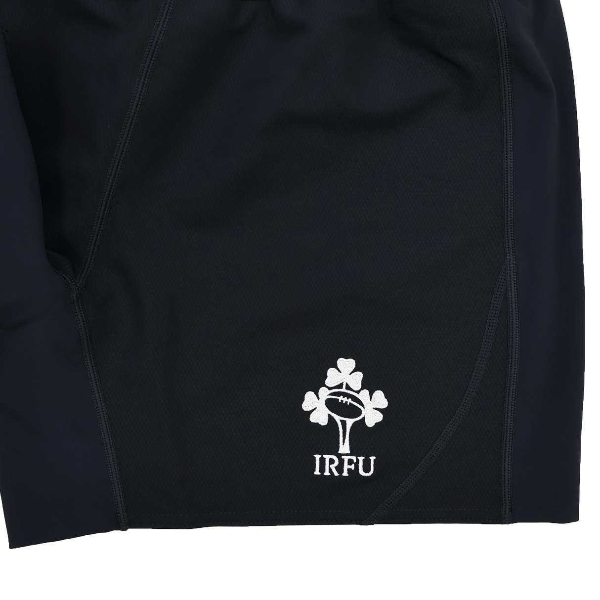 Close-up of the Ireland 25/26 Training Short by Canterbury, featuring the white IRFU logo with a rugby ball and shamrock embroidered on the lower hem.