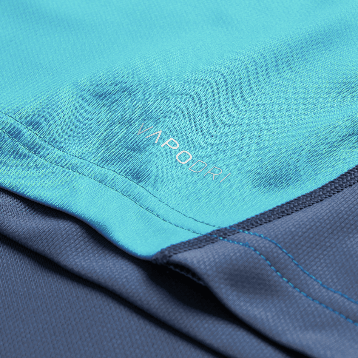 Close-up of blue athletic fabric from the Ireland 26/27 Summer Tour Training Pro Jersey by Canterbury, featuring "VAPODRI" print, detailed stitching, and textured Pro Fit style.