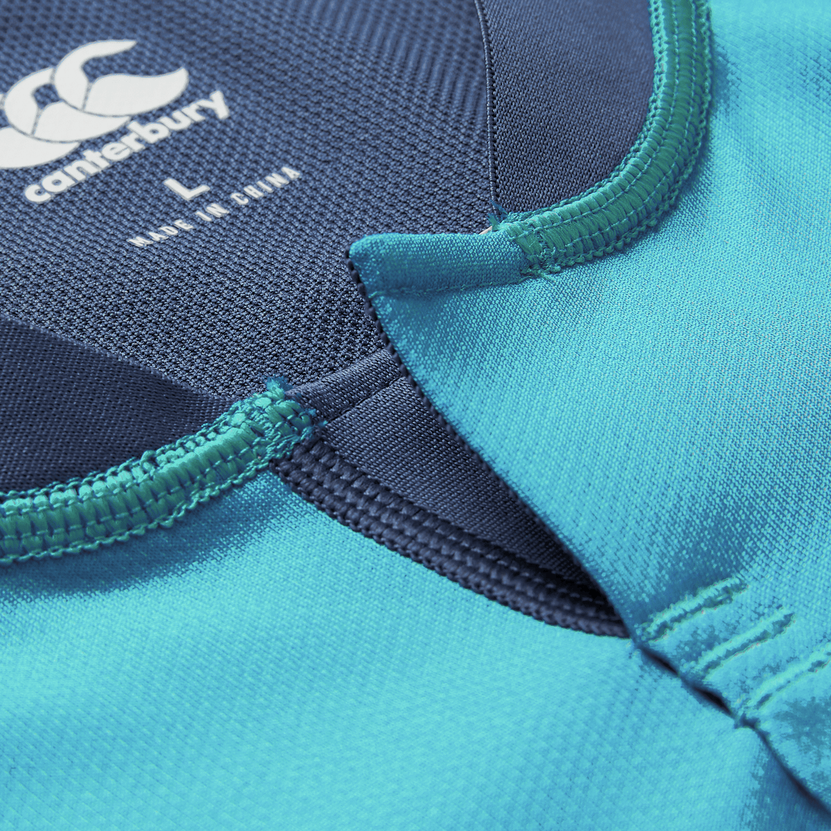 Close-up of the blue Ireland 26/27 Summer Tour Training Pro Jersey by Canterbury, highlighting the neckline, stitching, and brand logo with size label—ideal for fans of authentic Canterbury IRFU jersey styles.