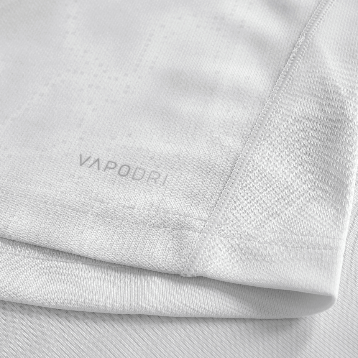 Close-up of the Youth Ireland 25/26 Alternate Pro Jersey by Canterbury in light grey, showing "VAPODRI" near the hem, detailed stitching, and textured fabric—an ideal pick for young rugby fans.