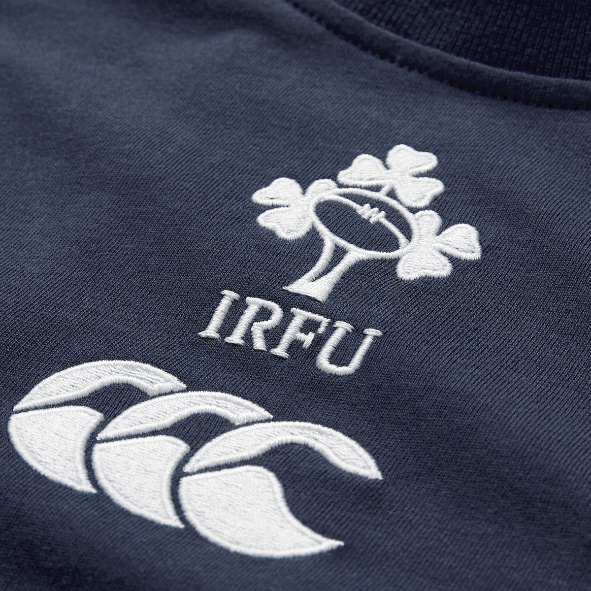 Close-up of the Ireland 26/27 Summer Tour Team Cotton T-Shirt by Canterbury in navy, showcasing the embroidered IRFU shamrock and white Canterbury logo—ideal for supporting Ireland this summer.