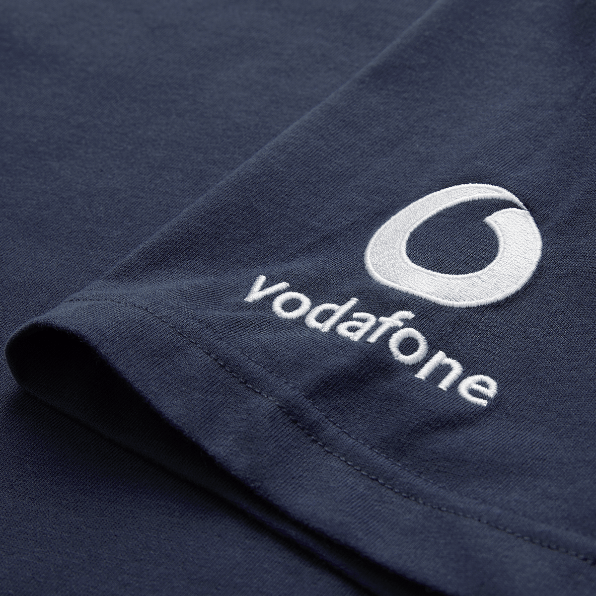 Close-up of the Ireland 26/27 Summer Tour Team Cotton T-Shirt by Canterbury in navy blue, with the Vodafone logo and name embroidered in white on the sleeve—ideal for supporting Ireland this summer.