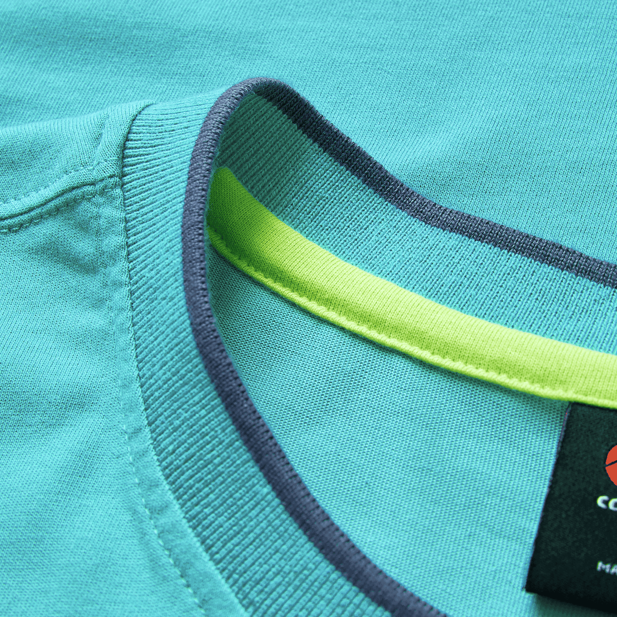 Close-up of the Ireland 26/27 Summer Tour Team Cotton T-Shirt by Canterbury, featuring a turquoise design, visible label, and lime green inner neck tape—an ideal addition to any Ireland Rugby T-Shirt collection.