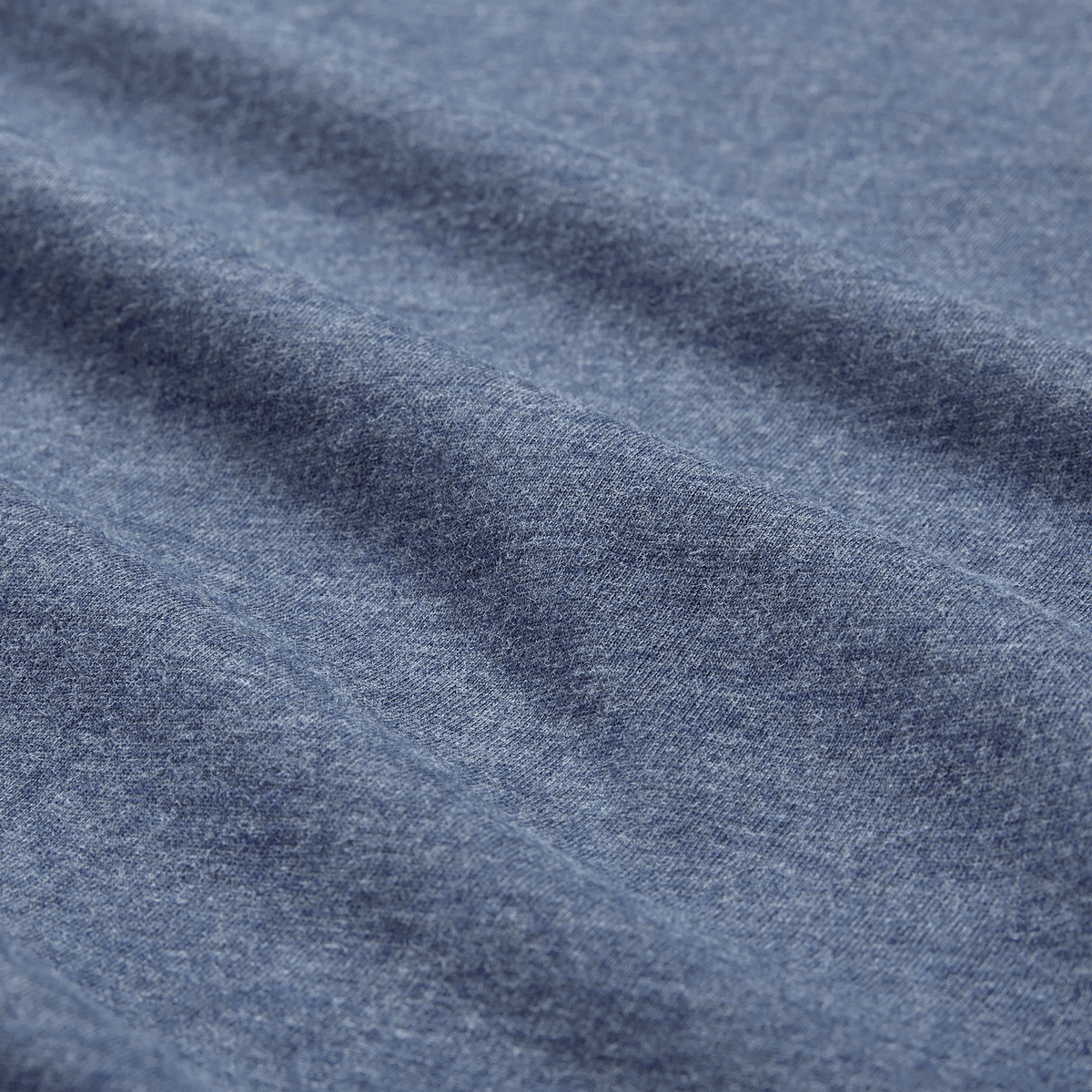 Close-up of blue heather fabric from the Ireland 26/27 Summer Tour Team Cotton T-Shirt by Canterbury, highlighting its texture and gentle horizontal folds—ideal for the season's rugby excitement.