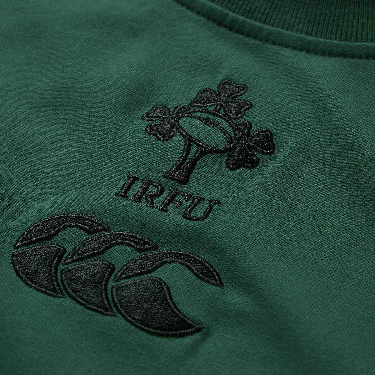 Close-up of a green fabric with embroidered IRFU and Canterbury logos in black thread, highlighting the quality of the Ireland 26 Team Cotton T-shirt by Canterbury.