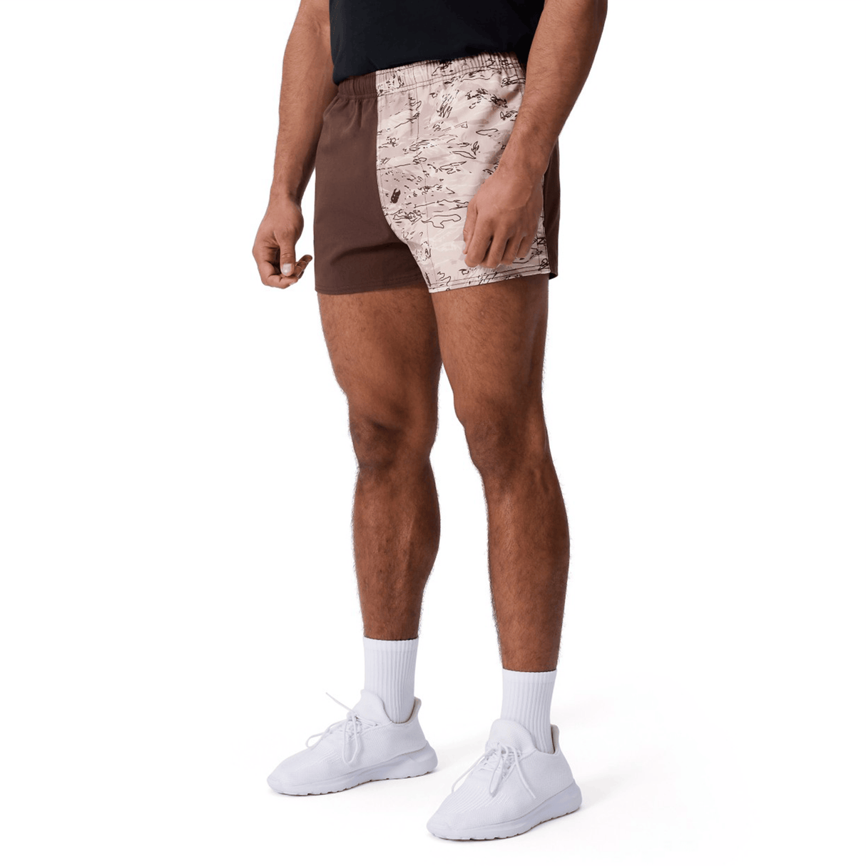 A person in Canterbury Force Harlequin Drill Shorts by Canterbury, featuring brown and beige patterns, paired with white socks and sneakers, stands against a white background.