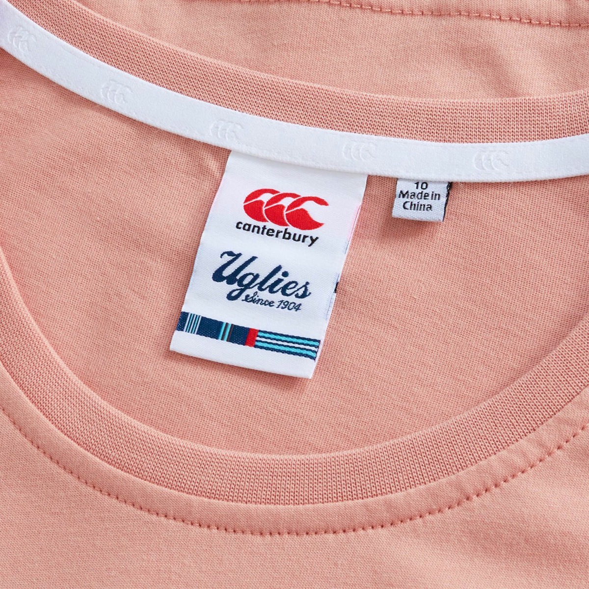 Close-up of the collar on the Women’s Canterbury Uglies Logo T-Shirt, highlighting the Canterbury “Uglies” label, size 10 marking, and a “Made in China” tag.
