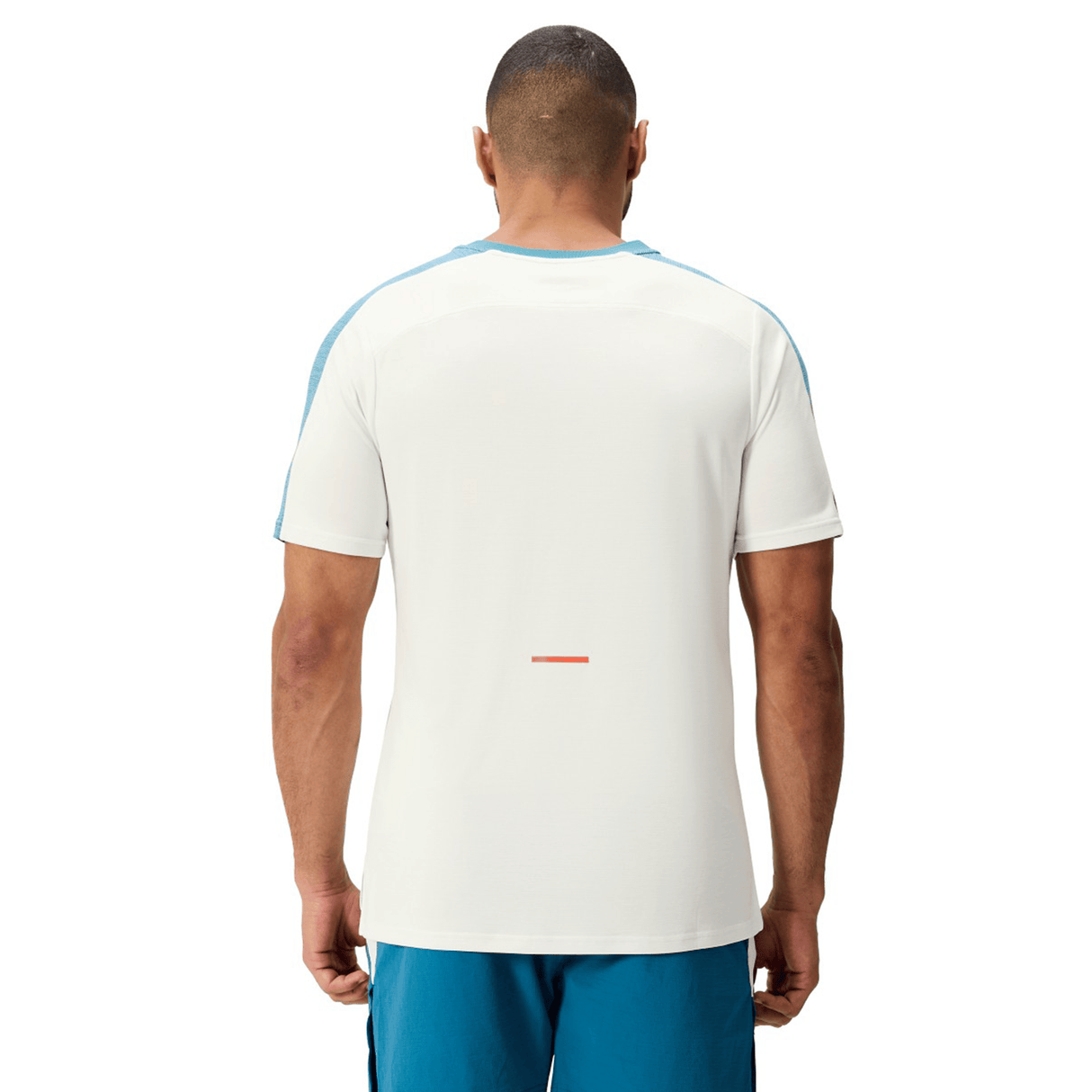 A man, seen from behind, wears a Canterbury Tempo Relaxed T-Shirt by Canterbury with blue accents and blue shorts, both crafted from breathable fabric, set against a plain background.