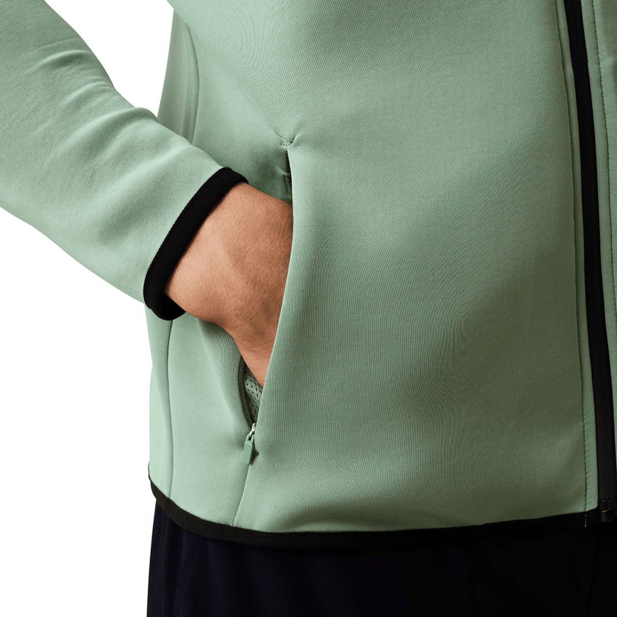 A person wearing a Canterbury Everest Zip Thru Hoodie in light green with black trim has their right hand in the side pocket.