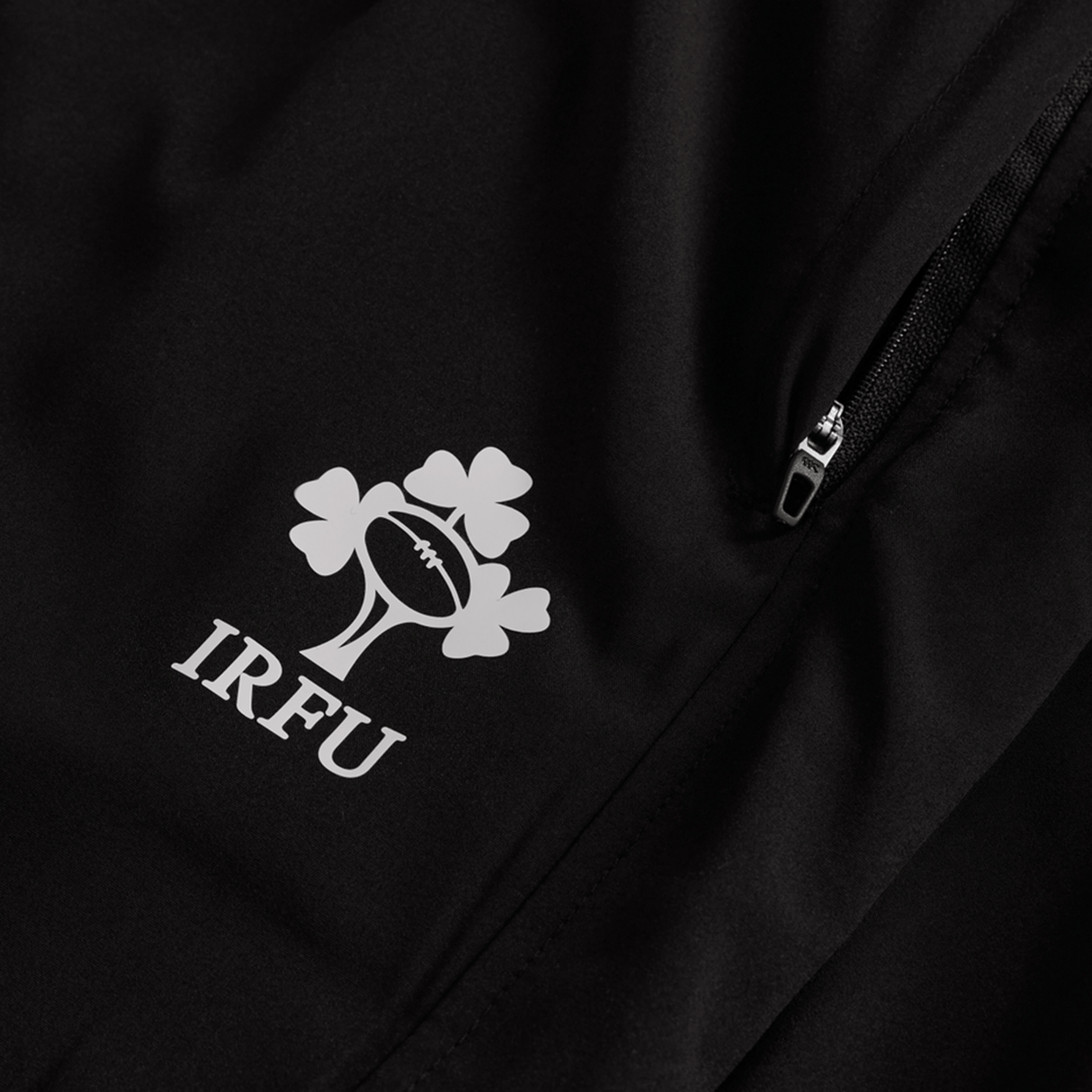 Close-up of a black Canterbury jacket with the IRFU logo beside a zippered pocket—ideal to pair with the Women's Ireland 25/26 Training Pant by Canterbury.