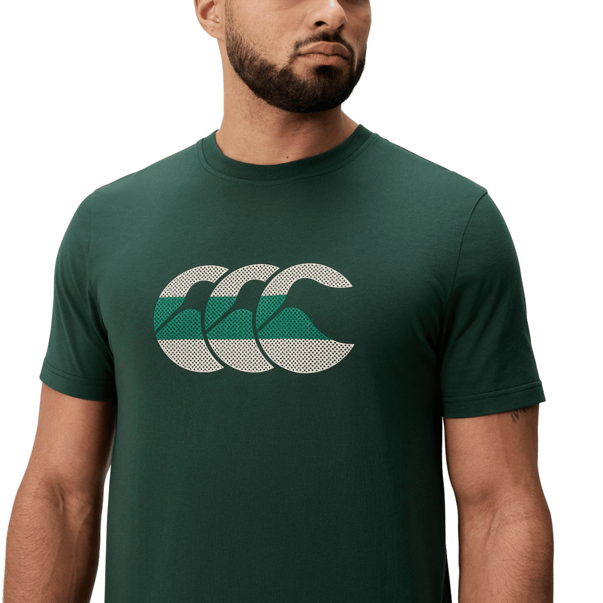 The Canterbury FUN. T-SHIRT AM features a man in a dark green tee with three overlapping white and green wave designs on the chest.