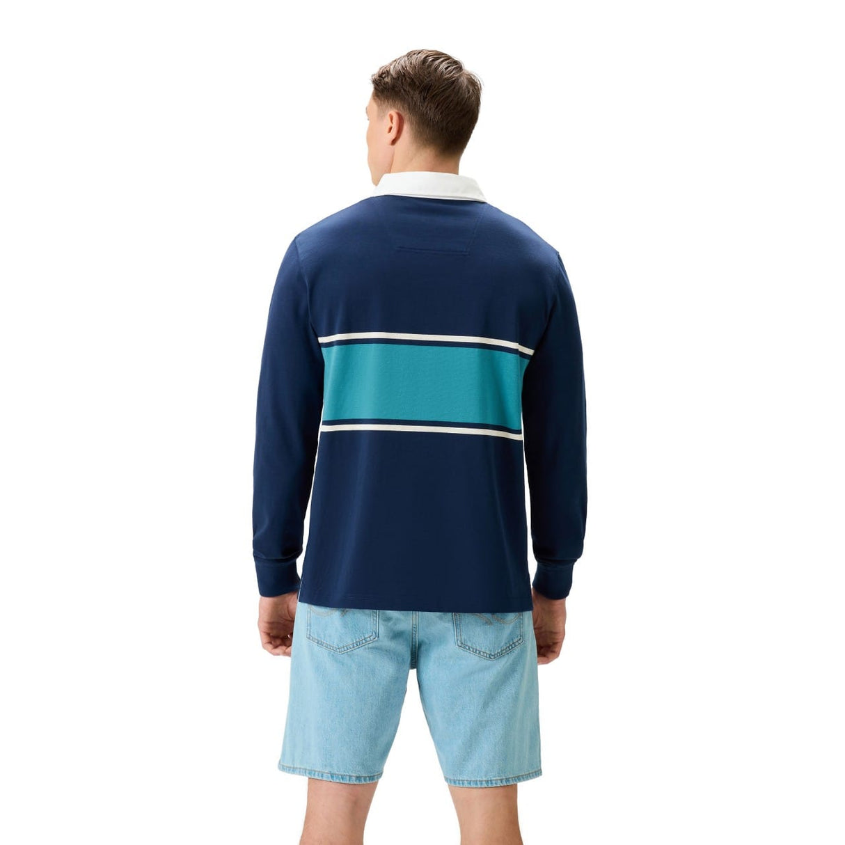 A man faces away wearing the Canterbury Stripe Rugby Jersey by Canterbury, featuring navy, teal, and white horizontal stripes, paired with light blue denim shorts.