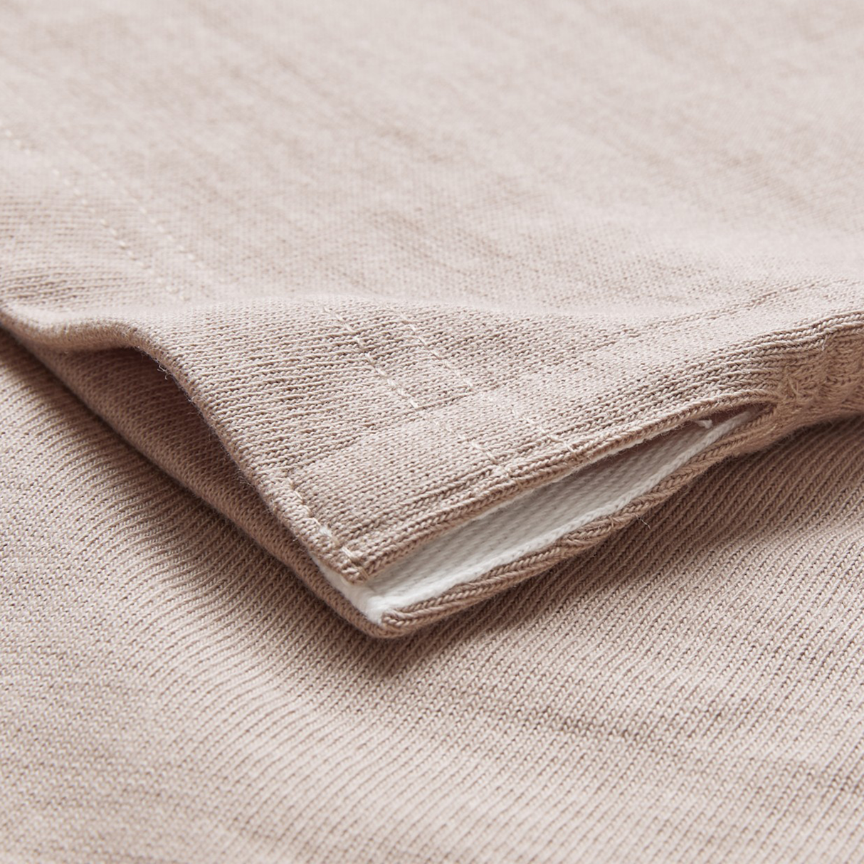 Close-up of the Canterbury Stripe Classic Rugby Jersey by Canterbury, showing the durable cotton blend fabric, folded hem with stitching detail, and a hint of the white inner layer.