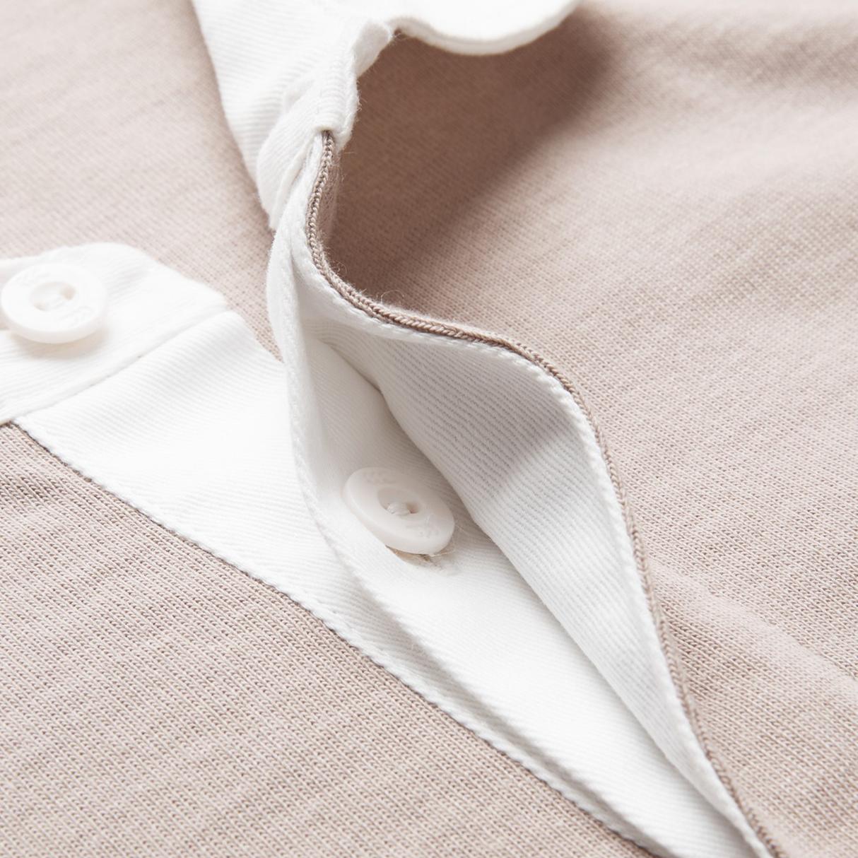 Close-up of the Canterbury Stripe Classic Rugby Jersey by Canterbury, made from a durable cotton blend with a beige finish, white button placket, and two white buttons, showcasing the shirt’s textured material.