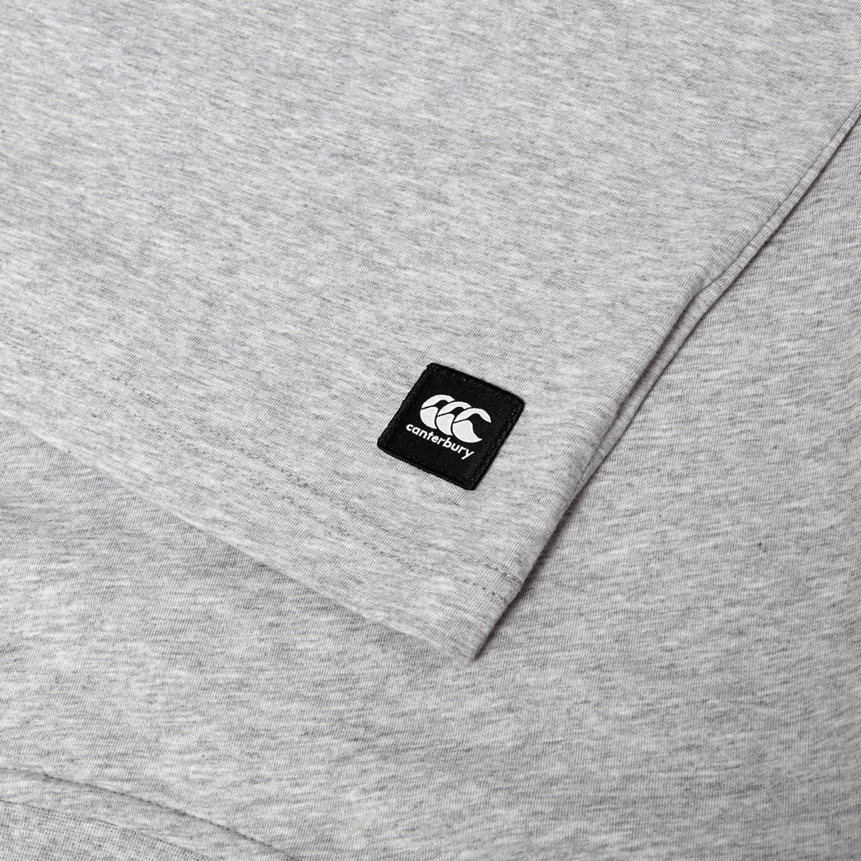 Close-up of the Canterbury Uglies Logo T-shirt, a grey cotton blend tee featuring a small black Canterbury logo patch sewn near the sleeve.