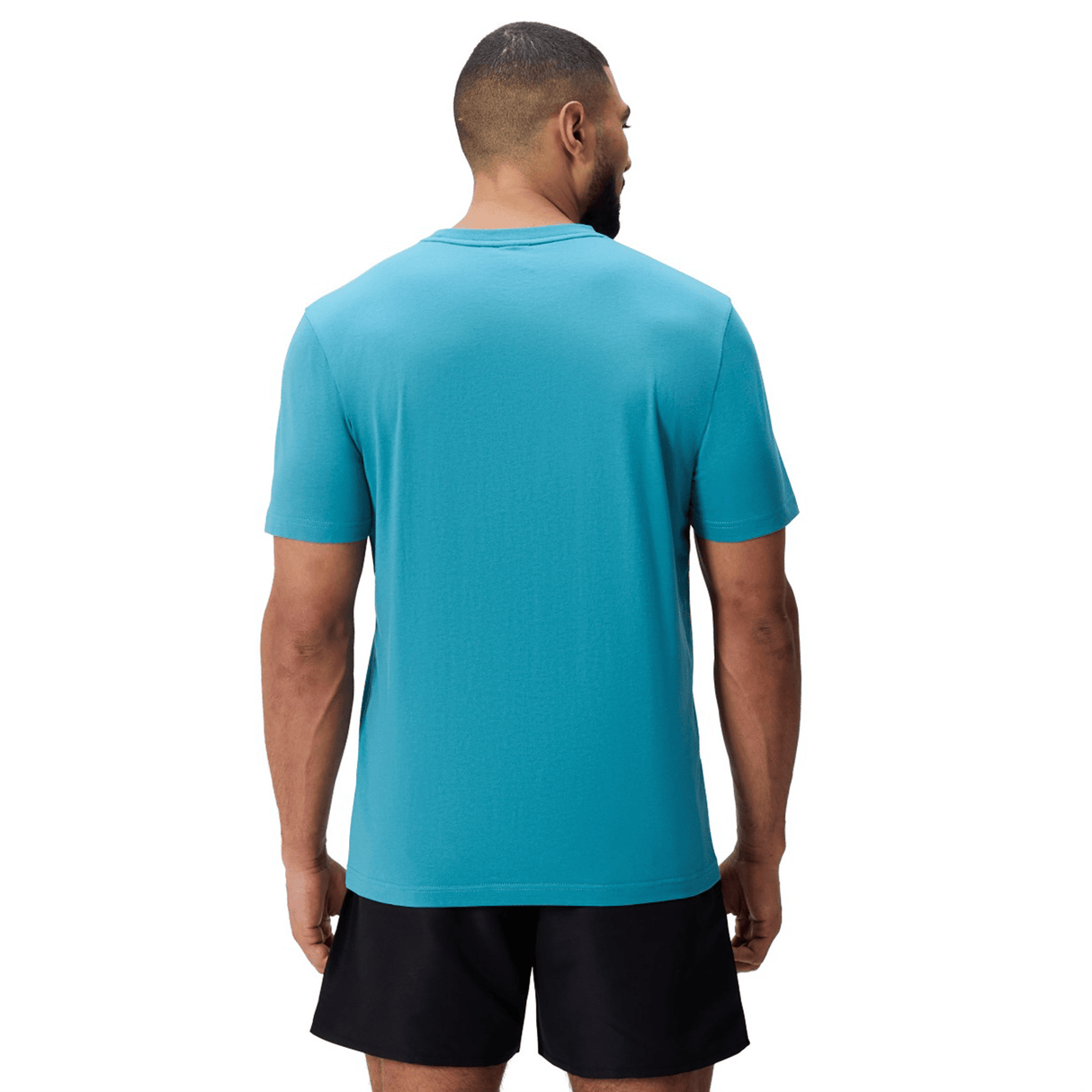 A man wearing a Canterbury Uglies Logo T-shirt by Canterbury stands facing away from the camera against a white background.