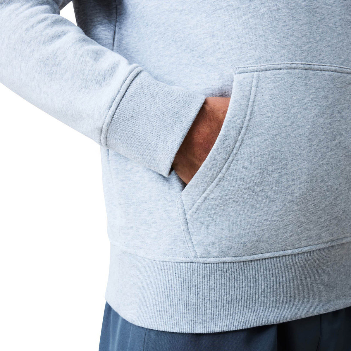 A person wearing a light gray Canterbury Uglies Logo Hoodie with their right hand in the front pocket, shown from the waist to mid-arm.