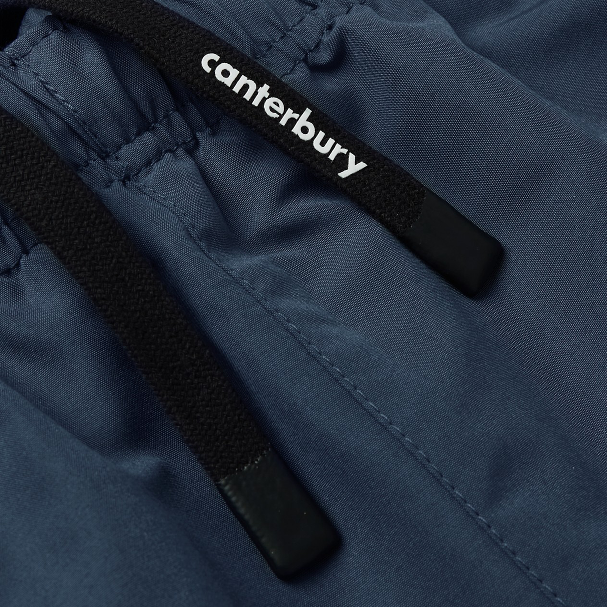 Close-up of navy blue fabric with black drawstrings, one showing the white “canterbury” logo—details from the Canterbury Uglies 32" Stadium Pant, premium rugby pants built by Canterbury for top athletic performance.